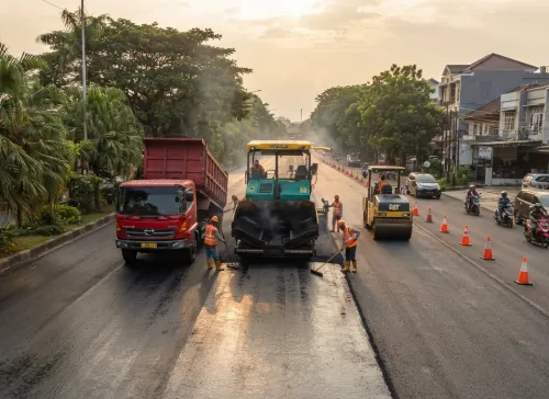 Pemandangan menyeluruh proyek pengaspalan jalan di Jakarta Selatan dengan alat berat dan tim pekerja profesional