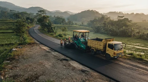 Proses jasa pengaspalan Cianjur dilihat dari sudut tinggi dengan alat berat dan truk