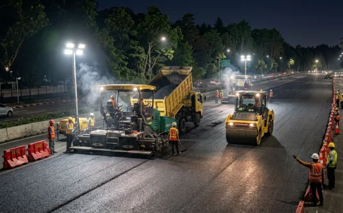 Proyek pengaspalan jalan protokol utama di Jakarta Pusat pada malam hari dengan alat berat lengkap